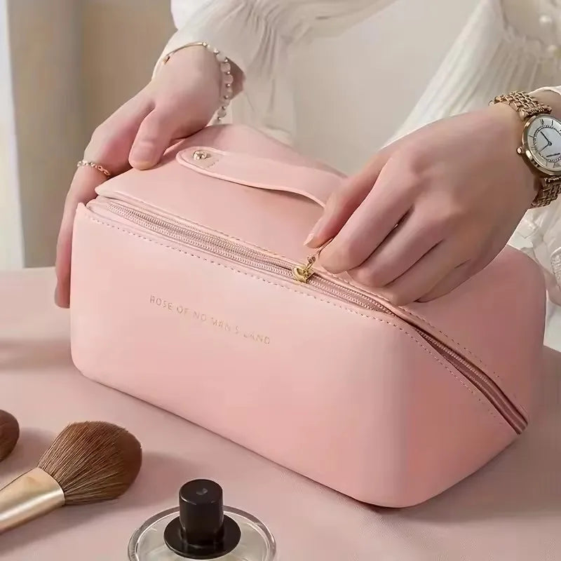 A person closing the smooth zipper on the elegant pink PU leather LuxeCase makeup bag.