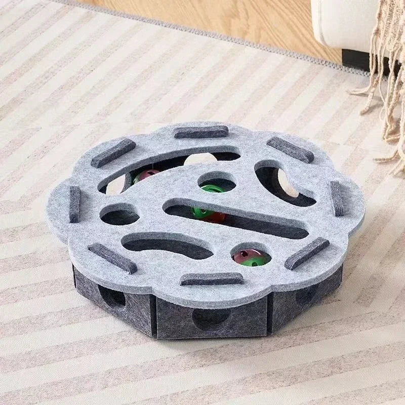 The flower-shaped interactive cat puzzle box in a light and dark grey felt material.