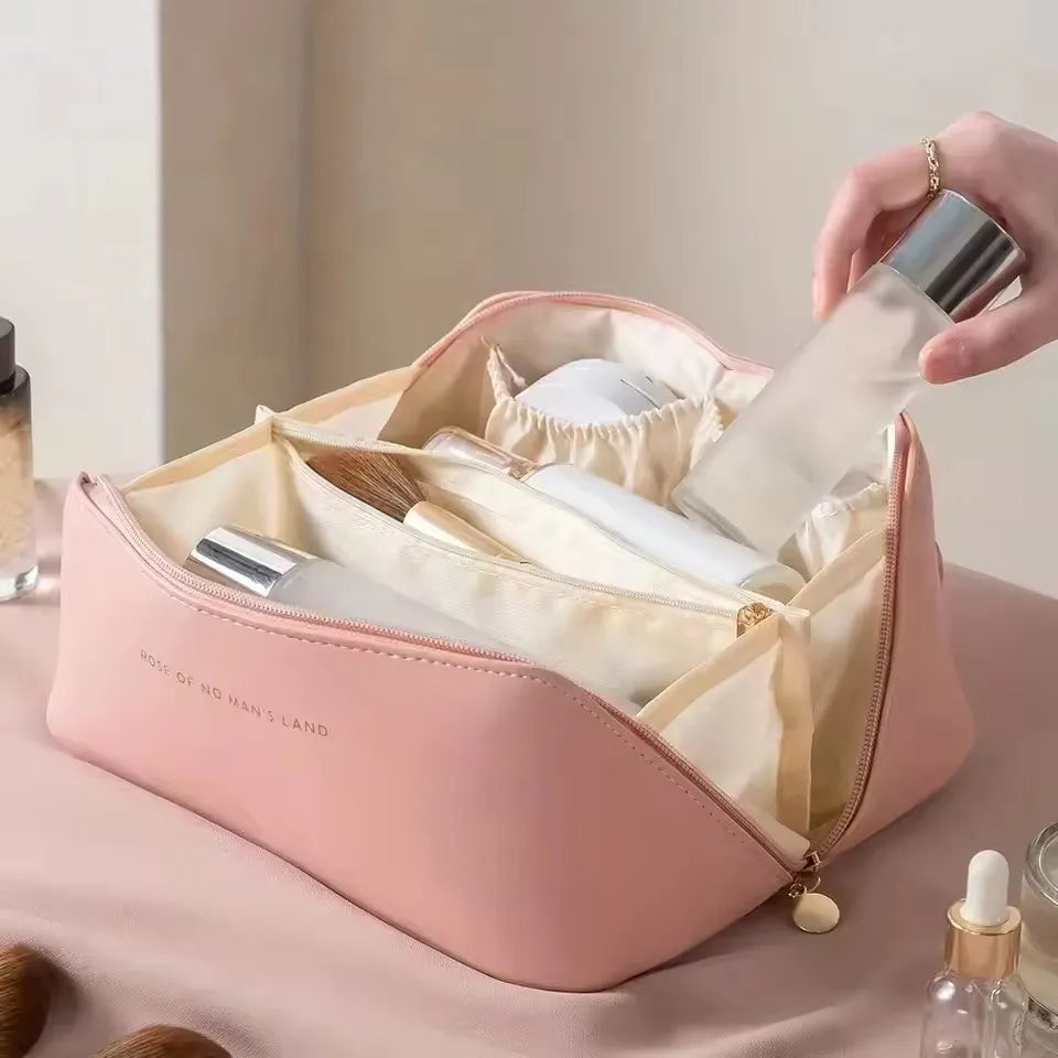 The pink PU leather LuxeCase makeup bag open, revealing its well-organized interior with compartments for brushes and bottles.