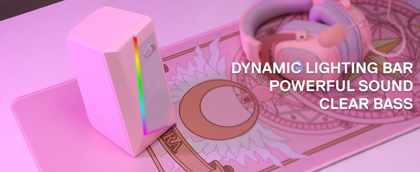 The pink Redragon GS520 speaker on a pink gaming mousepad next to headphones, with text highlighting "Dynamic Lighting Bar, Powerful Sound, Clear Bass".