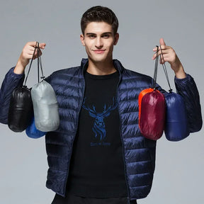 A model holding up five small, portable pouches containing the packed-down ArcticWave lightweight down jacket in various colors.