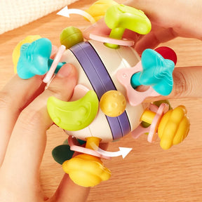 Close-up of hands rotating the colorful sensory parts of the soft silicone baby rattle cube.