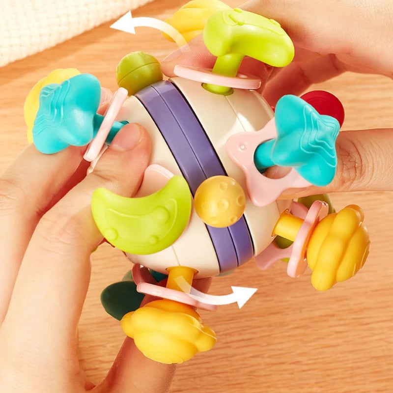 Close-up of hands rotating the colorful sensory parts of the soft silicone baby rattle cube.