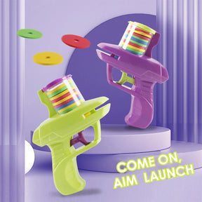 A green and a purple FunBox disc launcher toy gun shown in action, launching colorful soft foam discs.