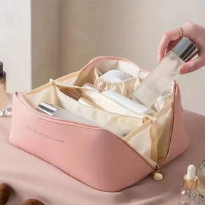 The pink PU leather LuxeCase makeup bag open, revealing its well-organized interior with compartments for brushes and bottles.
