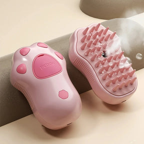 A product shot of the pink paw-shaped pet steamy brush, showing the steam function in action.