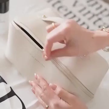 A video demonstrating the large capacity and organizational features of the LuxeCase PU leather makeup bag, showing various cosmetics being placed inside its compartments.