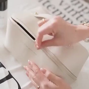A video demonstrating the large capacity and organizational features of the LuxeCase PU leather makeup bag, showing various cosmetics being placed inside its compartments.