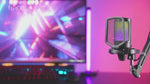 A promotional video for the FIFINE A6T microphone, showcasing its various color options, brilliant RGB lighting, tap-to-mute button, gain control adjustment, and compatibility with Windows, PS4/5, and Mac OS.