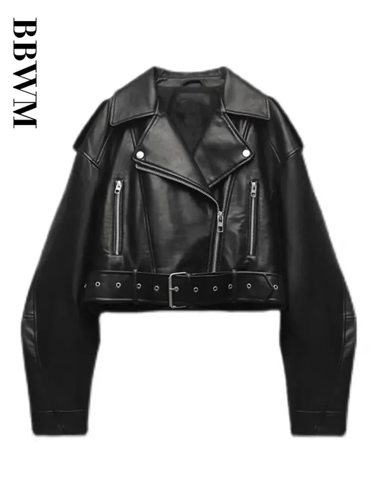 A product shot of the women's oversized moto jacket in black faux leather, showing the asymmetrical zip and belted waist.