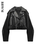 A product shot of the women's oversized moto jacket in black faux leather, showing the asymmetrical zip and belted waist.